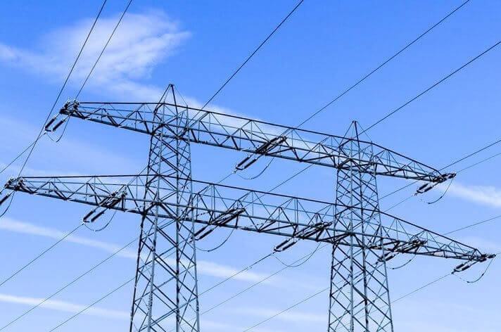 Zwei Strommasten vor blauem Himmel